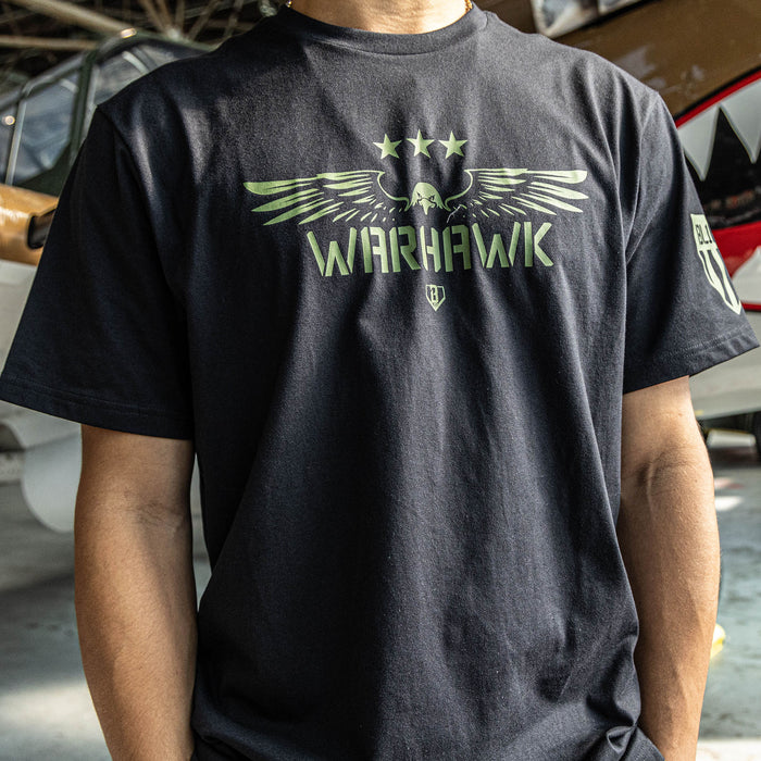 Close up of Black t-shirt featuring an army green eagle graphic with green “WARHAWK” lettering and a green Armor BL101 logo